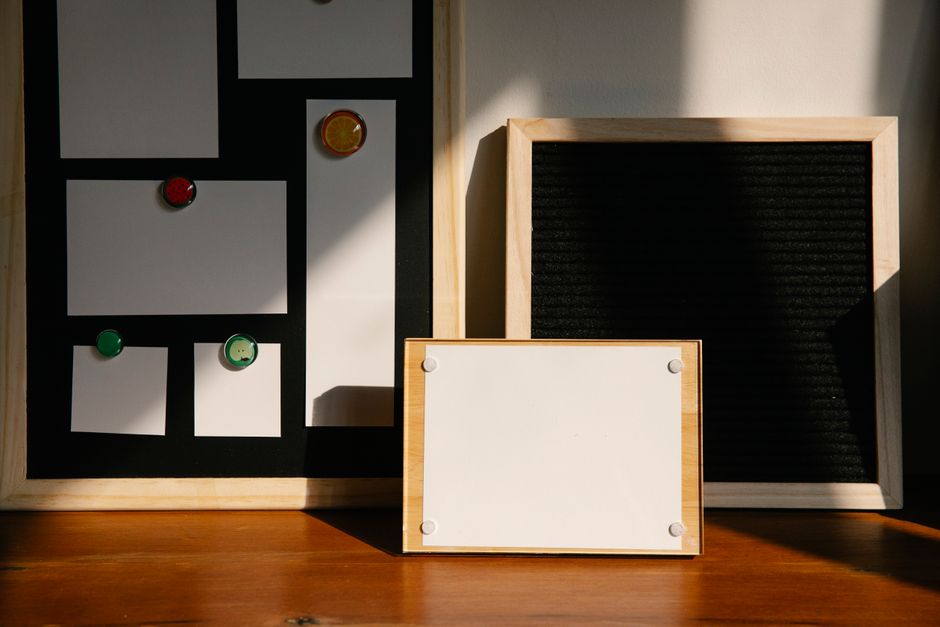 Three wooden-framed boards with magnets and placeholders on a wooden surface.